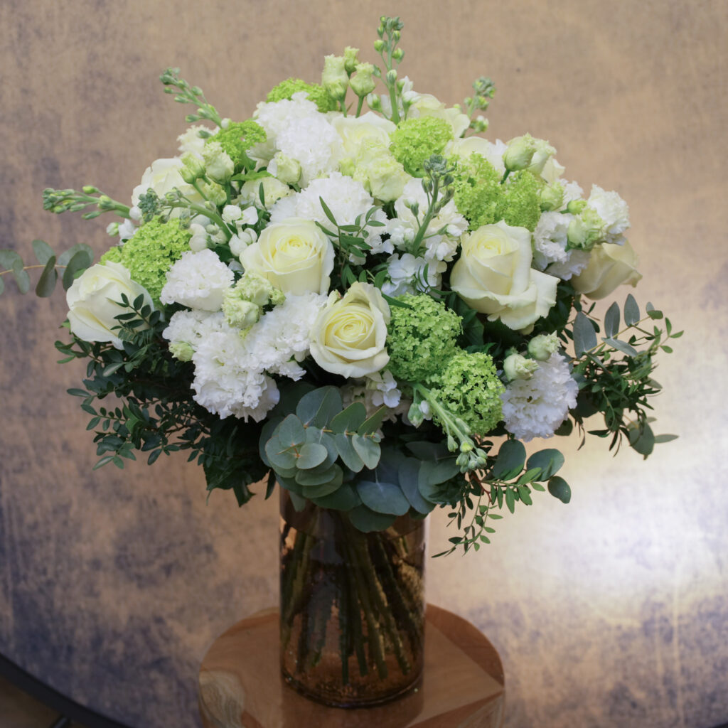 Bouquet Bergamote, une composition aux tons blancs et verts, associe roses blanches, lysianthus doubles, boules de neige et feuillages variés. Disponible en tailles S, M et L. Livraison rapide à Courchevel.